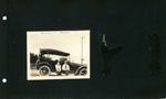 Edna and Russell Roberts sitting on running board of car.
