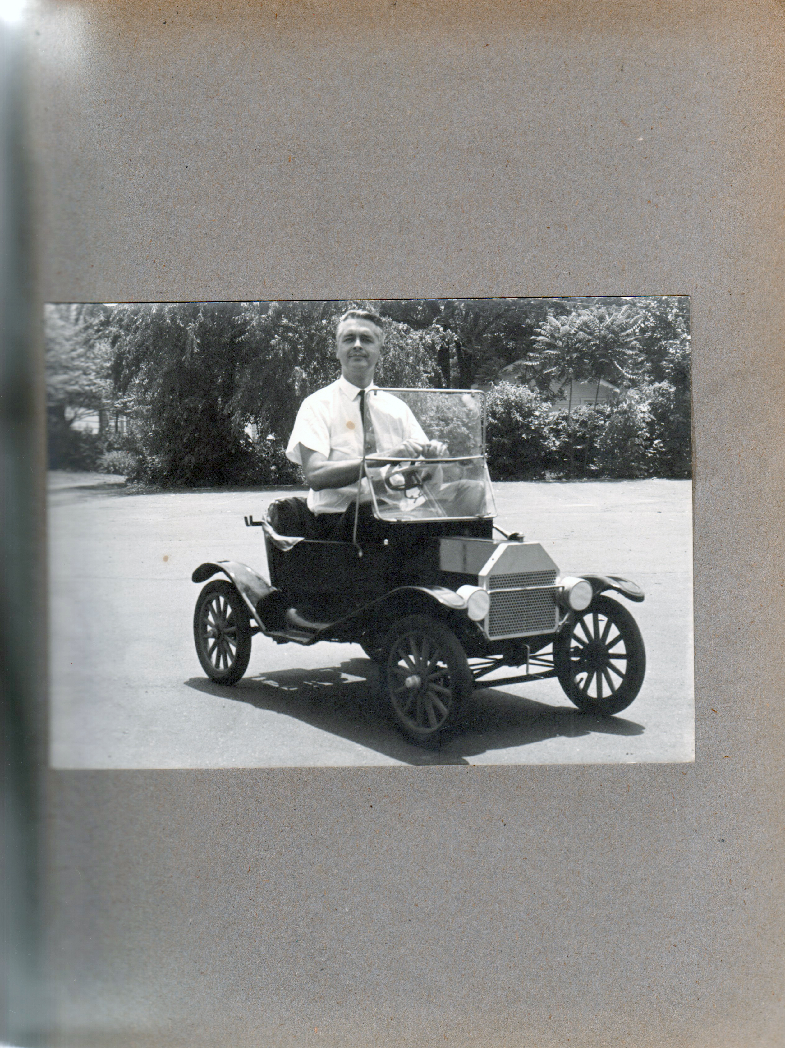 John driving little car in parking lot