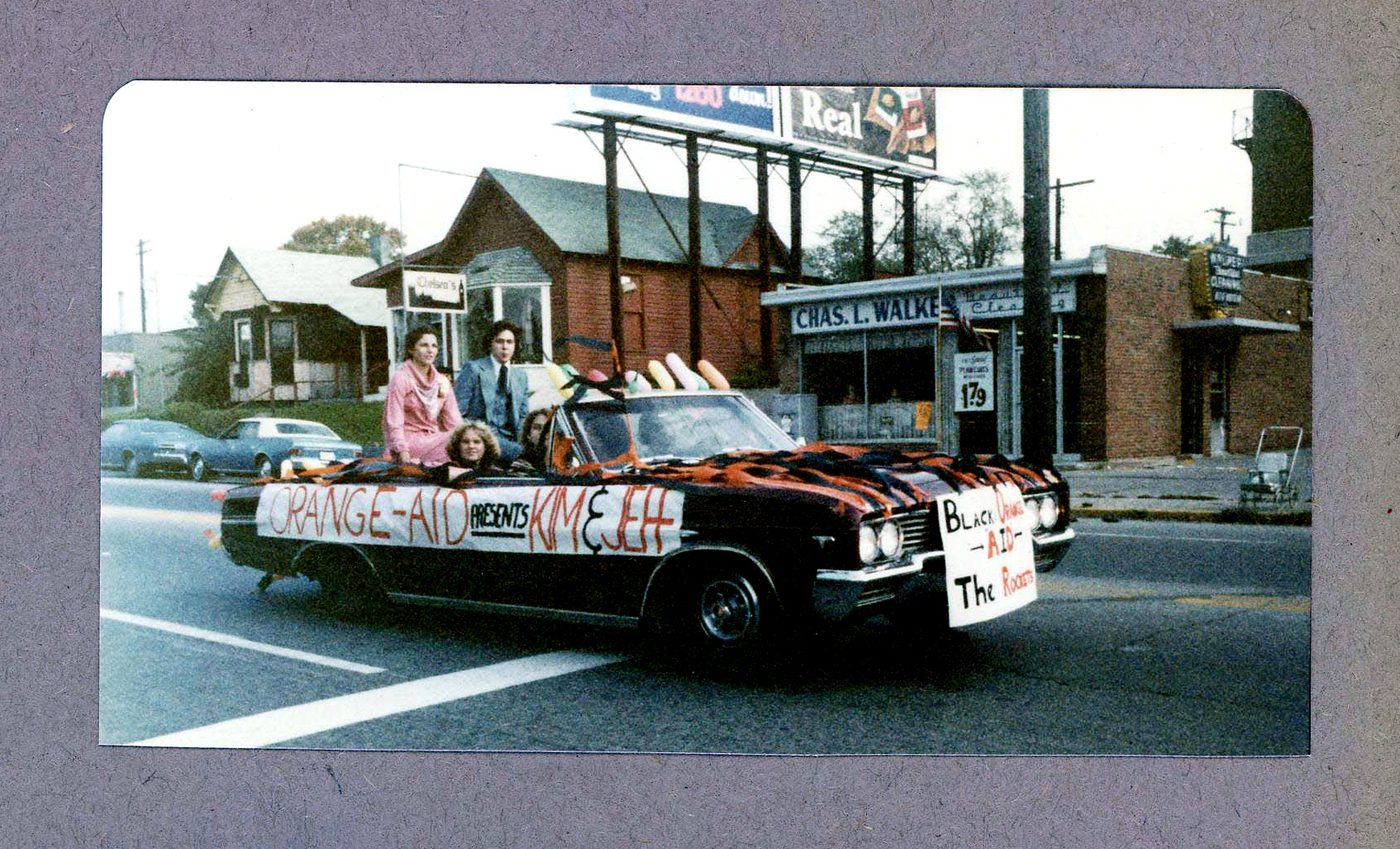 BRHS Homecoming parade passing by Walker Cleaners and Chelsea's on Broad Ripple Avenue - Kim Mitchell and Jeff ??? - Orange Aid float.